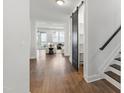 Open foyer with hardwood flooring, black barn door, and a view into the bright living room at 248 Daniel Ridge Rd, Wendell, NC 27591
