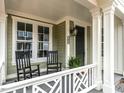 Charming front porch featuring decorative railings, seating, and a dark-stained front door at 2641 Sidford Aly, Raleigh, NC 27608