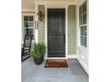 Inviting front porch with a dark front door, slate flooring, and rocking chair at 2641 Sidford Aly, Raleigh, NC 27608