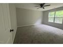Neutral bedroom featuring carpet, neutral paint, a ceiling fan, and a bright window at 300 Saturn St, Dunn, NC 28334