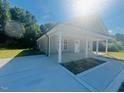 Inviting single-story home featuring a covered porch and a well-maintained driveway, nestled within lush greenery at 300 Saturn St, Dunn, NC 28334