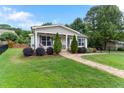 Quaint home with a well-maintained lawn, a charming stone walkway, and lush landscaping at 305 Georgetown Rd, Raleigh, NC 27608