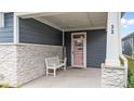 Inviting front porch with stone accents, a 'Welcome' sign, and a charming pink front door at 33 Davidson St, Clayton, NC 27527