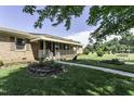 Well-manicured lawn and a brick home featuring a covered front porch at 403 E Mcpherson Dr, Mebane, NC 27302