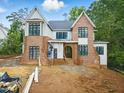 New two-story home featuring a brick facade, light gray siding and black-framed windows surrounded by a landscaped yard at 5013 Coronado, Raleigh, NC 27609