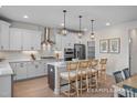 Bright kitchen featuring white cabinets, stainless steel appliances, and an island with barstool seating at 5060 Trotter Dr, Raleigh, NC 27603