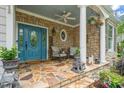 Beautiful front porch with stone detail, comfortable seating, and a stylish blue door create a welcoming entrance at 5405 Bluet Ct, Holly Springs, NC 27540