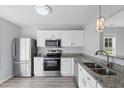Modern kitchen featuring stainless steel appliances, granite countertops, and white cabinets at 5408 Gunnette Dr, Raleigh, NC 27610