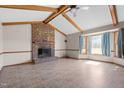 Bright living room featuring exposed beams, a brick fireplace, neutral walls, and a bay window at 5437 Grasshopper Rd, Raleigh, NC 27610