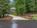 Secluded brick home with a long driveway nestled among mature trees, offering privacy and curb appeal at 5805 Laurel Rock Ln, Raleigh, NC 27613