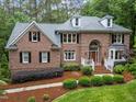 Charming brick home with a well-maintained lawn, attractive landscaping, and classic shutters on all the windows at 5805 Laurel Rock Ln, Raleigh, NC 27613
