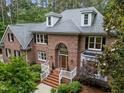 Imposing brick home with lush landscaping and attractive walkway leading to the arched entryway and covered portico at 5805 Laurel Rock Ln, Raleigh, NC 27613