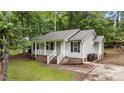 Cozy one-story home with light siding, black shutters, and a welcoming front porch, set amidst a green lawn and trees at 627 Gaslight Trl, Wendell, NC 27591