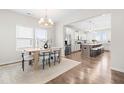 Bright dining area featuring a modern chandelier, wood table, and seamless transition to a well-equipped kitchen at 66 Arlie Ln, Lillington, NC 27546