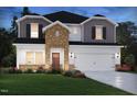 New home with two-car garage, dark shutters, brick and gray siding for a contemporary aesthetic at 667 White Birch Ln, Angier, NC 27501