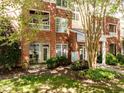 Brick condo building showing an outdoor patio and balcony, surrounded by lush greenery at 8231 Allyns Landing Way # 101, Raleigh, NC 27615