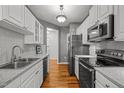 Modern kitchen featuring stainless steel appliances, granite countertops, and wood flooring at 8231 Allyns Landing Way # 101, Raleigh, NC 27615