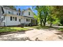 View of the rear of the property, featuring a screened in porch and a large parking area at 830 S Chestnut St, Henderson, NC 27536