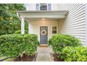 Close-up of front door with welcome mat, wreath and beautiful shrubbery at 925 Spring Meadow Dr, Durham, NC 27713