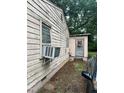 Side of building with weathered, peeling paint and an old air conditioning unit at 1002 Loius St, Burlington, NC 27217