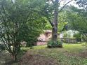 Home exterior with front porch and ramp surrounded by large shady trees at 1002 Loius St, Burlington, NC 27217