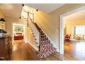 Elegant foyer with hardwood floors, staircase with patterned runner, and classic archway entrances at 1002 Vance St, Raleigh, NC 27608