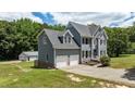 This exterior view reveals a charming two-story home with a large garage and a detached garage at 102 Ridge Ln, Youngsville, NC 27596