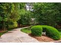 Long winding driveway leading up to home on private lot with mature trees and manicured front yard at 103 Red Cedar Pl, Chapel Hill, NC 27514