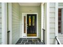 Close-up of a stylish front door with decorative glass panels and black hardware, set in a slate porch at 103 Red Cedar Pl, Chapel Hill, NC 27514