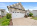 Close up of a two-car garage with carriage style doors, and a well-manicured lawn at 104 Spindle Dr, Durham, NC 27703
