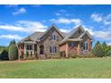 Attractive stone and brick home boasts well-maintained landscaping and a vibrant green lawn at 105 Somerley Dr, Garner, NC 27529