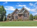 Stunning stone and brick home with professionally landscaped yard and lush, green lawn at 105 Somerley Dr, Garner, NC 27529