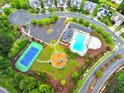 Aerial view of community amenities including a pool, playground, tennis court, and parking, surrounded by greenery at 110 Elmsford St, Durham, NC 27707