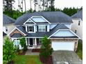 Aerial view of a charming two-story home with stone accents, manicured lawn, and an attached garage at 110 Elmsford St, Durham, NC 27707
