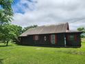 Quaint one-story cabin featuring a brown metal roof and a spacious green lawn at 111 Matthews Mill Pond Rd, Angier, NC 27501
