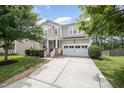 Charming two-story home with a manicured lawn, two-car garage, and covered front porch at 1211 Whispering Oak Ln, Durham, NC 27704