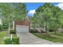 Desirable brick home with an attached two-car garage, mature landscaping, and a long driveway at 1309 Caribou Xing, Durham, NC 27713