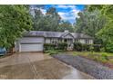 Traditional home with mature trees, manicured bushes and landscaping, and attached garage on a lush, green lot at 1311 Theodore Ln, Durham, NC 27703