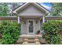 Inviting covered front porch with white columns, dual lanterns, and decorative bushes surrounding the entrance at 1311 Theodore Ln, Durham, NC 27703
