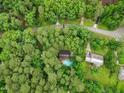 Aerial view of a secluded property surrounded by lush trees with a swimming pool next to the main home at 14 Gloucester Ct, Durham, NC 27713