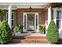 Inviting front entrance featuring a brick facade, decorated door with wreath, and well-maintained landscaping at 1603 Timber Wolf Dr, Durham, NC 27713