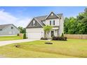 Beautiful two-story home showcasing a well-maintained yard, an attached garage and mature tree at 18 Dot Dr, Wendell, NC 27591