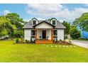 Beautifully landscaped two story home with black trimmed windows and inviting front porch at 18 W Academy St, Wendell, NC 27591
