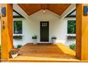 Inviting front porch with solid wood supports, seating area, and black trimmed windows at 18 W Academy St, Wendell, NC 27591