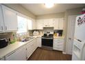 Functional kitchen with white cabinets, modern appliances, and durable flooring at 1910 Trexler Ct, Raleigh, NC 27606