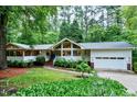 Charming single-story home with lush landscaping, bright white exterior, and attached two-car garage at 2004 Flagstone Pl, Raleigh, NC 27612