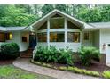 Inviting front entrance with a brick walkway and garden, leading to a modern home with large windows at 2004 Flagstone Pl, Raleigh, NC 27612