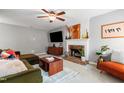 Cozy living room featuring a fireplace, comfortable seating, and a ceiling fan at 202 Stonecreek Dr, Apex, NC 27539