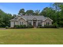 Charming home with stone accents, manicured landscaping, and a well-maintained lawn creates a welcoming curb appeal at 2208 Wimberly Woods Dr, Sanford, NC 27330