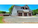 Three-car garage with an upper balcony, ample parking space, and well-maintained landscaping at 2258 Sanders Rd, Stem, NC 27581